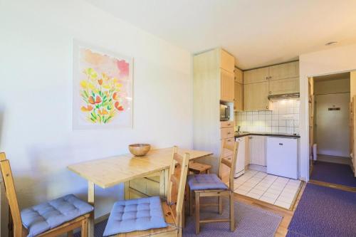 une cuisine avec une table et des chaises dans une pièce dans l'établissement Résidence Arbaron - maeva Home - Studio 4 personnes - Confort MAE-8638, à Flaine