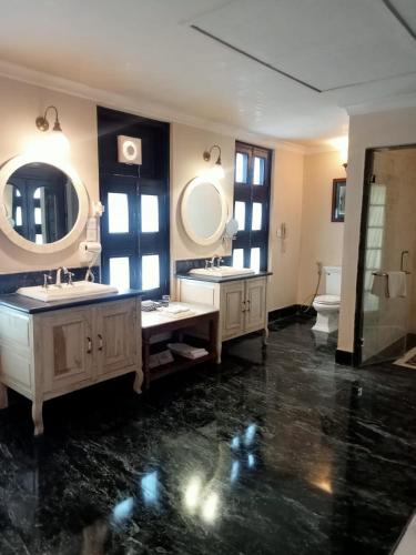 a large bathroom with two sinks and two mirrors at Juna Mahal Jungle Resort Ranthambore in Sawāi Mādhopur