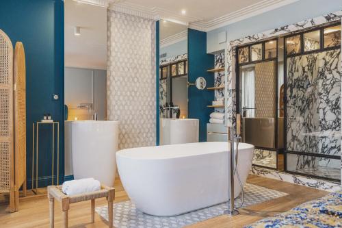 a bathroom with a large tub and two sinks at Hôtel Singulier Bordeaux in Bordeaux