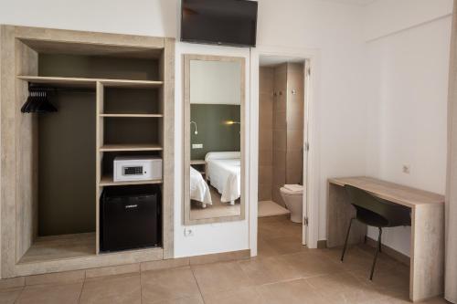 サンアントニオにあるオスタル アリカンテのバスルーム(ベッド1台、鏡付)が備わる客室です。