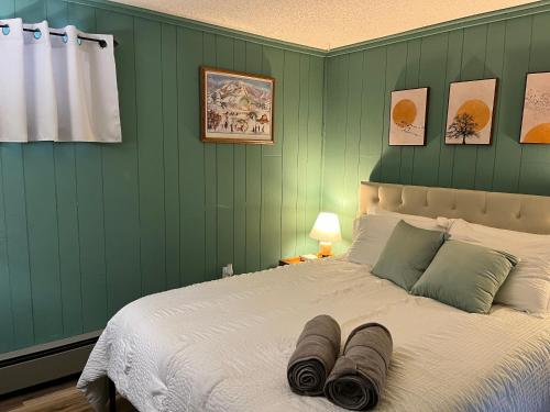 a bedroom with a large bed with green walls at Snow Otter Haus - 1 in Bessemer