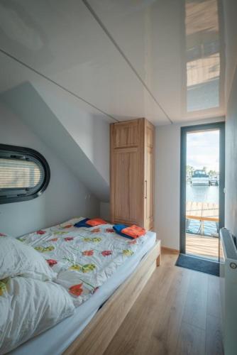 a small bedroom with a bed and a window at Hausboot Püntenel - stationär - Traumhafte Ferienwohnung AUF dem Wasser in Tolkamer
