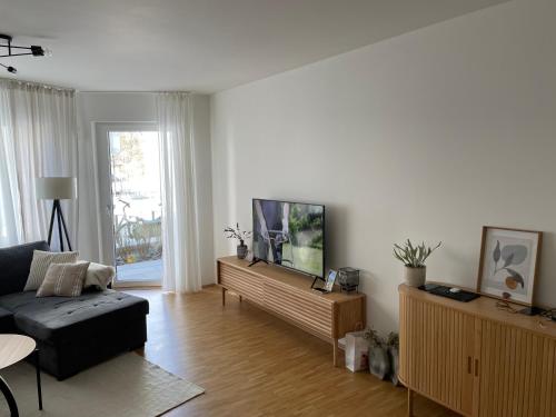 sala de estar con sofá y TV de pantalla plana en Ferienwohnung mit Innenstadtanbindung en Múnich