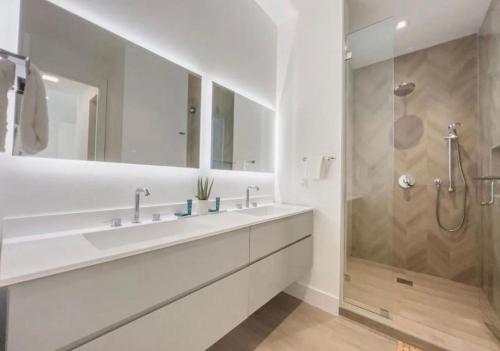 a white bathroom with a sink and a shower at Coconut Groove Green s VIlla in Miami