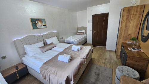 a bedroom with a large bed with two boxes on it at ЕЛЕГАНС къща за гости in Dospat
