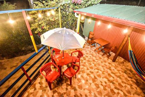 a table and chairs with an umbrella on a patio at Casa do Passarinho in Campos do Jordão