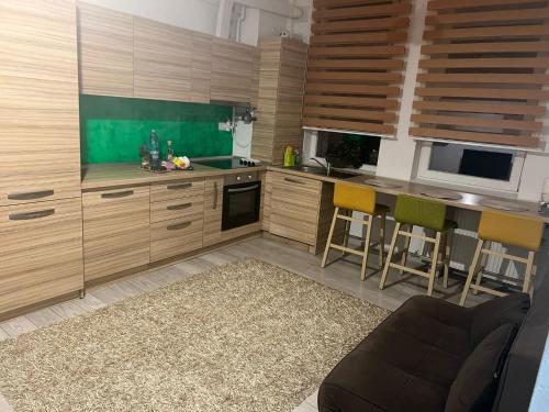 una cocina con armarios de madera y sillas amarillas en Apartament Claudia en Baia Mare