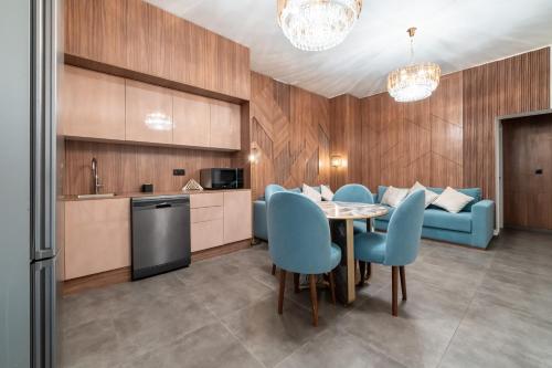 una cucina e una sala da pranzo con tavolo e sedie blu di luxueuse chambre de haut standing 1 a Bruxelles