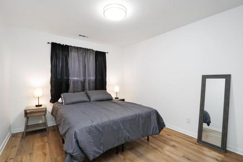 a bedroom with a large bed and a mirror at Elegant 2BR Escape in Manhattan with WiFi & Parking in Manhattan