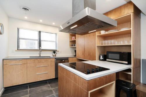 a kitchen with wooden cabinets and a stove top oven at Elegant 2BR Escape in Manhattan with WiFi & Parking in Manhattan