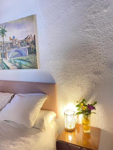 a bedroom with a bed and a vase of flowers on a table at Pink Lemon House in Elche