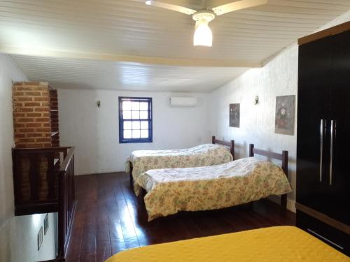 a room with two beds and a window at Apartamento no Centro de Búzios in Búzios