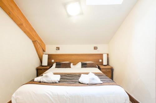 um quarto com uma cama com duas almofadas brancas em Résidence Les Terrasses d'Eos - maeva Home - Appartement 2 pièces 4 personne 034 em Arâches-la-Frasse