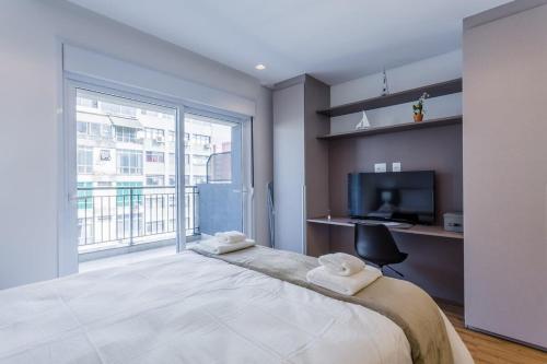1 dormitorio con 1 cama grande, escritorio y TV en BHomy Bela Vista Completo e localização APM1204 en São Paulo