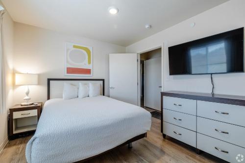a bedroom with a bed and a flat screen tv at WaterWalk Extended Stay by Wyndham Wichita in Wichita