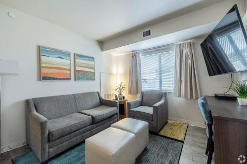 a living room with a couch and two chairs at WaterWalk Extended Stay by Wyndham Wichita in Wichita