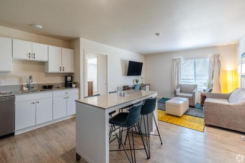 an open kitchen and living room with a counter and chairs at WaterWalk Extended Stay by Wyndham Wichita in Wichita