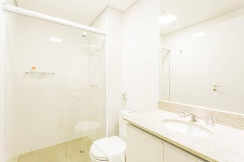 a white bathroom with a toilet and a glass shower at BHomy Bela Vista Sacada e Ar APM1209 in São Paulo