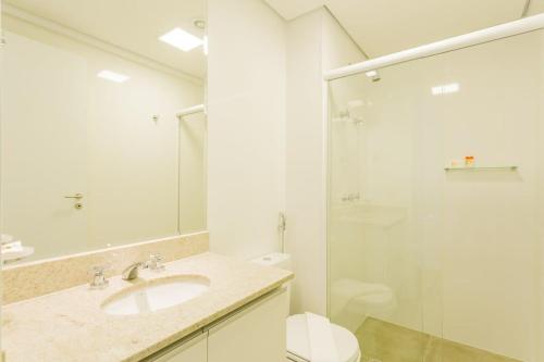 ein weißes Bad mit einem Waschbecken und einer Dusche in der Unterkunft Studio redecorado no Bela Vista com Sacada e Lazer APM1205 in São Paulo