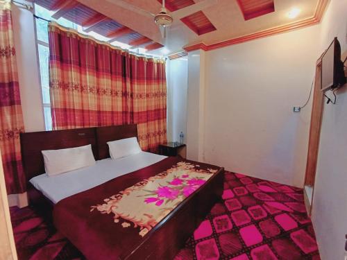 a bedroom with a bed with flowers on it at Stay Inn Hotel in Mingāora