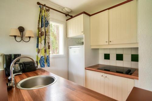 une cuisine avec un évier et un réfrigérateur dans l'établissement Les Maisons du Domaine du Golf de Pinsolle - maeva Home - Maison 3 pièces 6 personnes - Sélection MAE-6364, à Soustons