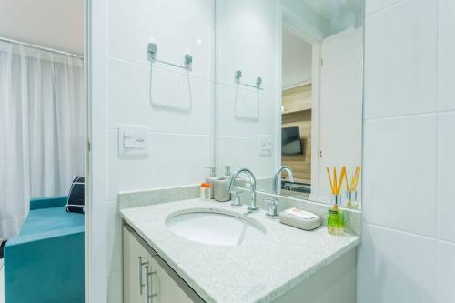 ein Bad mit einem Waschbecken und einem Spiegel in der Unterkunft BHomy Brooklin Moderno e com vista linda GB132B in São Paulo