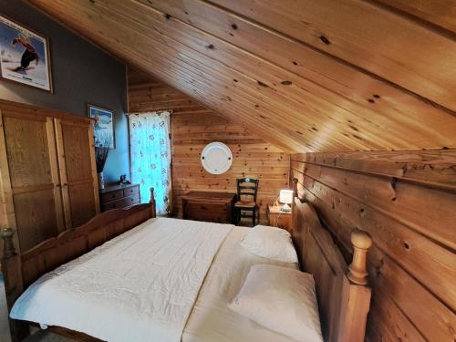 une chambre avec un lit dans une cabane en bois dans l'établissement Les Chalets de Flaine Hameau - maeva Home - Chalet 5 Pièces 8 Personnes - Sélection MAE-2135, à Flaine