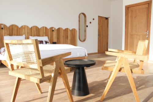 1 dormitorio con 2 sillas de madera y 1 cama en Loku, en Matara