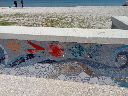 a mosaic tile on a wall next to the beach at B&B Villa Alma in San Costanzo