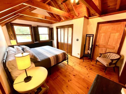 um quarto com uma cama e uma mesa com um candeeiro em Don Quixote Lakefront log cabin em Eufaula