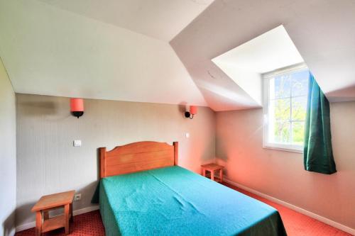 une chambre avec un lit bleu et une fenêtre dans l'établissement La résidence du Lac - maeva Home - Maison 2 pièces 5 personnes - Sélection MAE-0094, à Monflanquin
