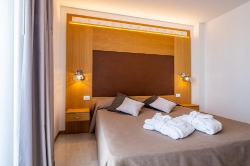 a bedroom with a bed with towels on it at Hotel Mare in Lignano Sabbiadoro