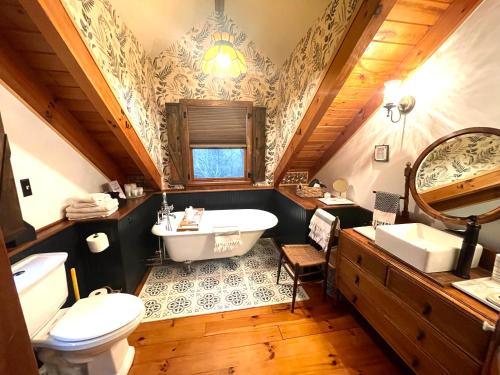 uma casa de banho com uma banheira, um WC e um lavatório. em Don Quixote Lakefront log cabin em Eufaula