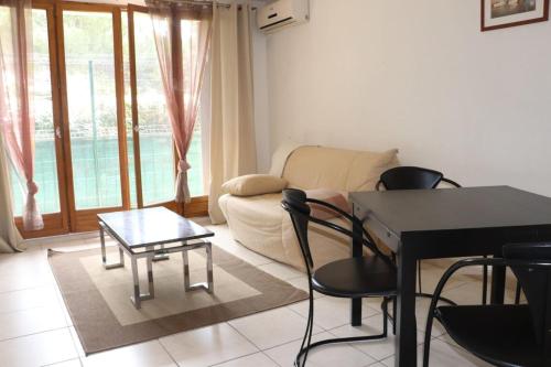 ein Wohnzimmer mit einem Tisch, Stühlen und einem Sofa in der Unterkunft Gionova furnished flat in Aix-en-Provence