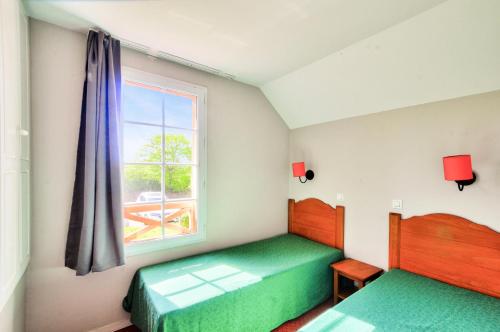 une chambre avec deux lits et une fenêtre dans l'établissement La résidence du Lac - maeva Home - Maison 3 pièces 8 personnes - Sélection MAE-5594, à Monflanquin