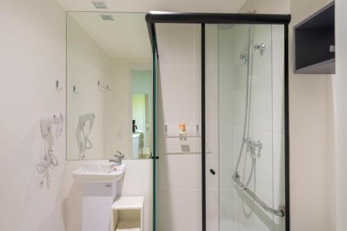a bathroom with a shower and a toilet and a sink at BHomy Brooklin - Com varanda espaçosa BUR205 in Sao Paulo