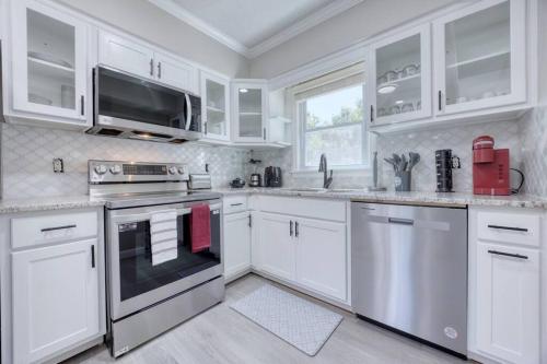 a kitchen with white cabinets and stainless steel appliances at New! Comfy Home with Playground Near Ft Moore! in Columbus