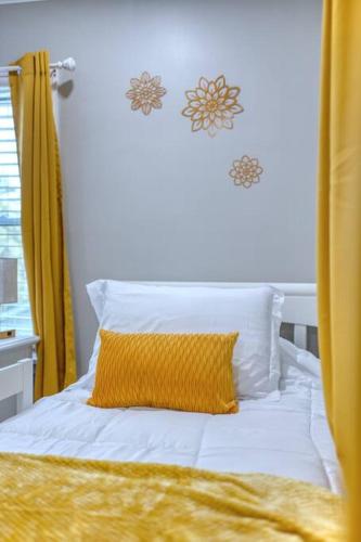 a bed with a yellow blanket and a yellow pillow at New! Comfy Home with Playground Near Ft Moore! in Columbus