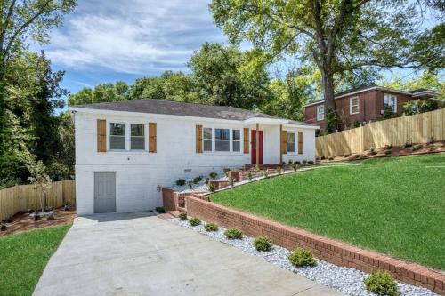 a white house with a fence and a yard at New! Comfy Home with Playground Near Ft Moore! in Columbus