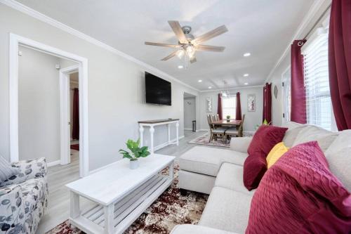 a living room with a white couch and a ceiling fan at New! Comfy Home with Playground Near Ft Moore! in Columbus