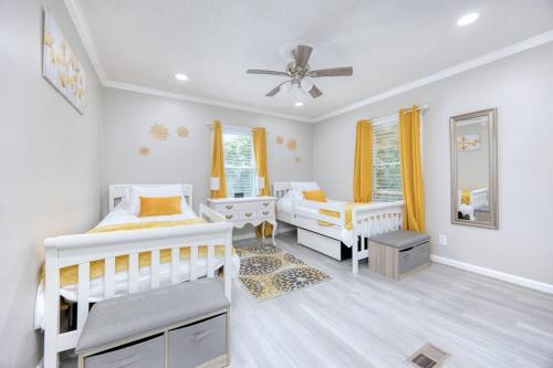 a bedroom with two beds and a ceiling fan at New! Comfy Home with Playground Near Ft Moore! in Columbus