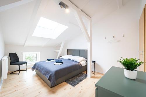1 dormitorio blanco con 1 cama y 1 silla en Gemütliches Apartment, en Magdeburgo