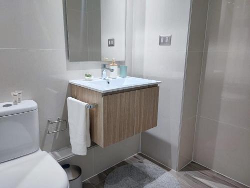 La salle de bains est pourvue d'un lavabo et de toilettes. dans l'établissement Encantador depto 2D2B con estacionamiento vista al MAR ServicioHOM, à Antofagasta
