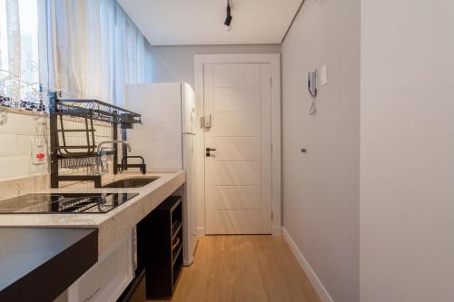 eine Küche mit einer Spüle und einem weißen Kühlschrank in der Unterkunft BHomy Paulista - Novo e bem localizado MR44 in São Paulo
