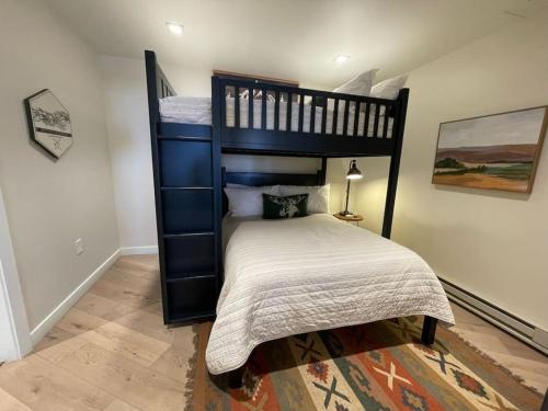 a bedroom with a black bunk bed with a white bedspread at Ski In-Out Hot Tub Gym Sauna Pool Reserved Parking-503 in Brighton
