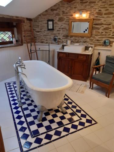 uma banheira na casa de banho com um lavatório em Au coeur des loges em Saint-Bonnet-de-Bellac