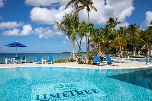 a swimming pool with chairs and the ocean at Caribbean Life in St. Thomas in Bolongo