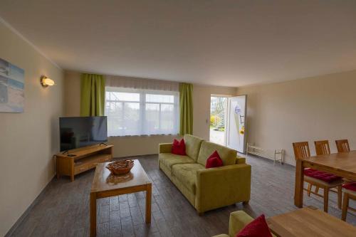ein Wohnzimmer mit einem Sofa und einem TV in der Unterkunft Ferienanlage Süderhof in Breege