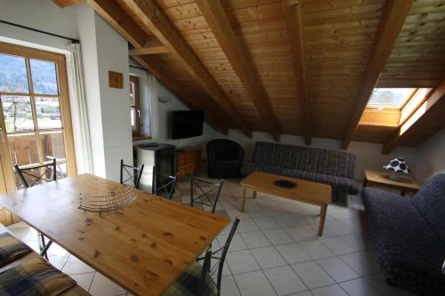 un salon avec une table et un canapé dans l'établissement Ferienwohnung Almhüttenweg Dreitorspitze, à Garmisch-Partenkirchen