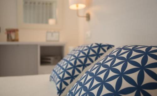 almohada azul y blanca en una cama en una habitación en Hotel Rosamar - Emar Hotels en Es Pujols